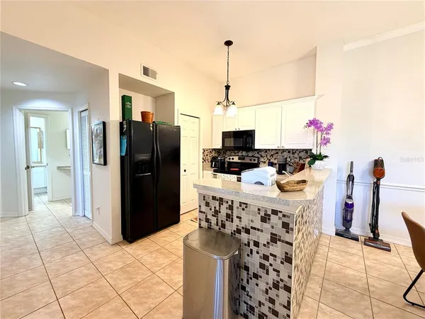 a kitchen with stainless steel appliances kitchen island granite countertop a stove top oven a sink a counter space and cabinets