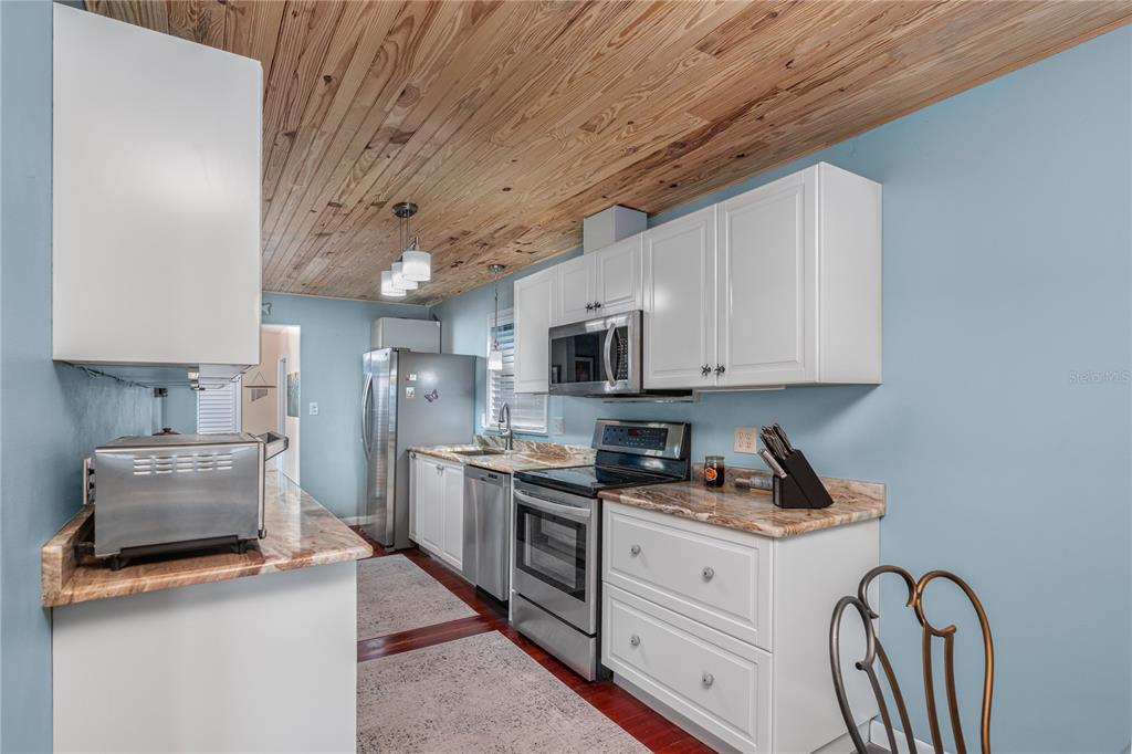 2518 Fort Lane Road Geneva, FL 32732 - Photo 22 of 44 a kitchen with stainless steel appliances granite countertop a lot of cabinets a stove and a refrigerator
