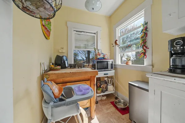a living room with furniture a clock on wall and a window