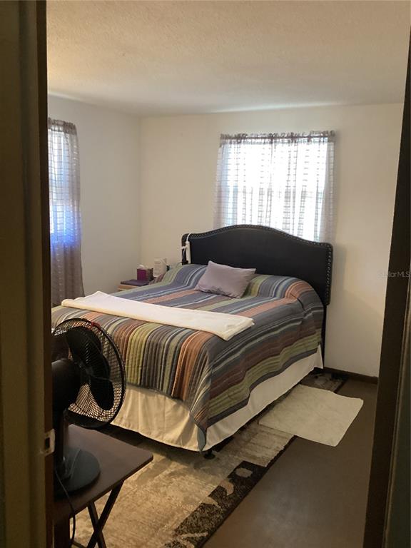 10029 Brandywine Lane Port Richey, FL 34668 - Photo 8 of 11 a bedroom with a bed and windows