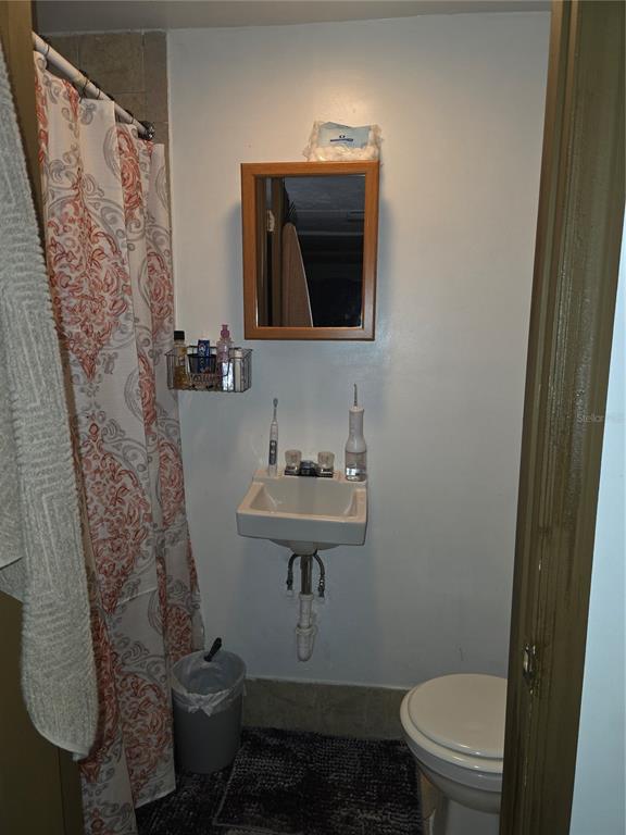 10029 Brandywine Lane Port Richey, FL 34668 - Photo 9 of 11 a bathroom with a toilet sink and mirror