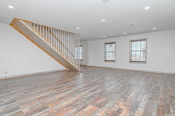 a view of room with wooden floor and staircase