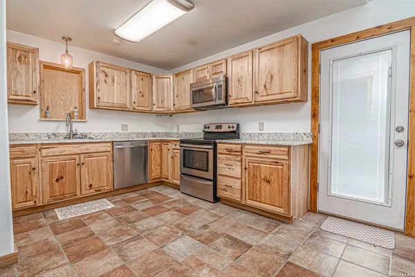 a kitchen with stainless steel appliances granite countertop a stove sink and cabinets