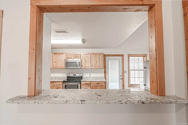 a view of kitchen with kitchen island granite countertop cabinets and outdoor space