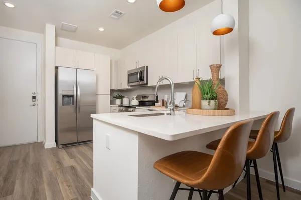 a kitchen with stainless steel appliances a dining table chairs and chandelier