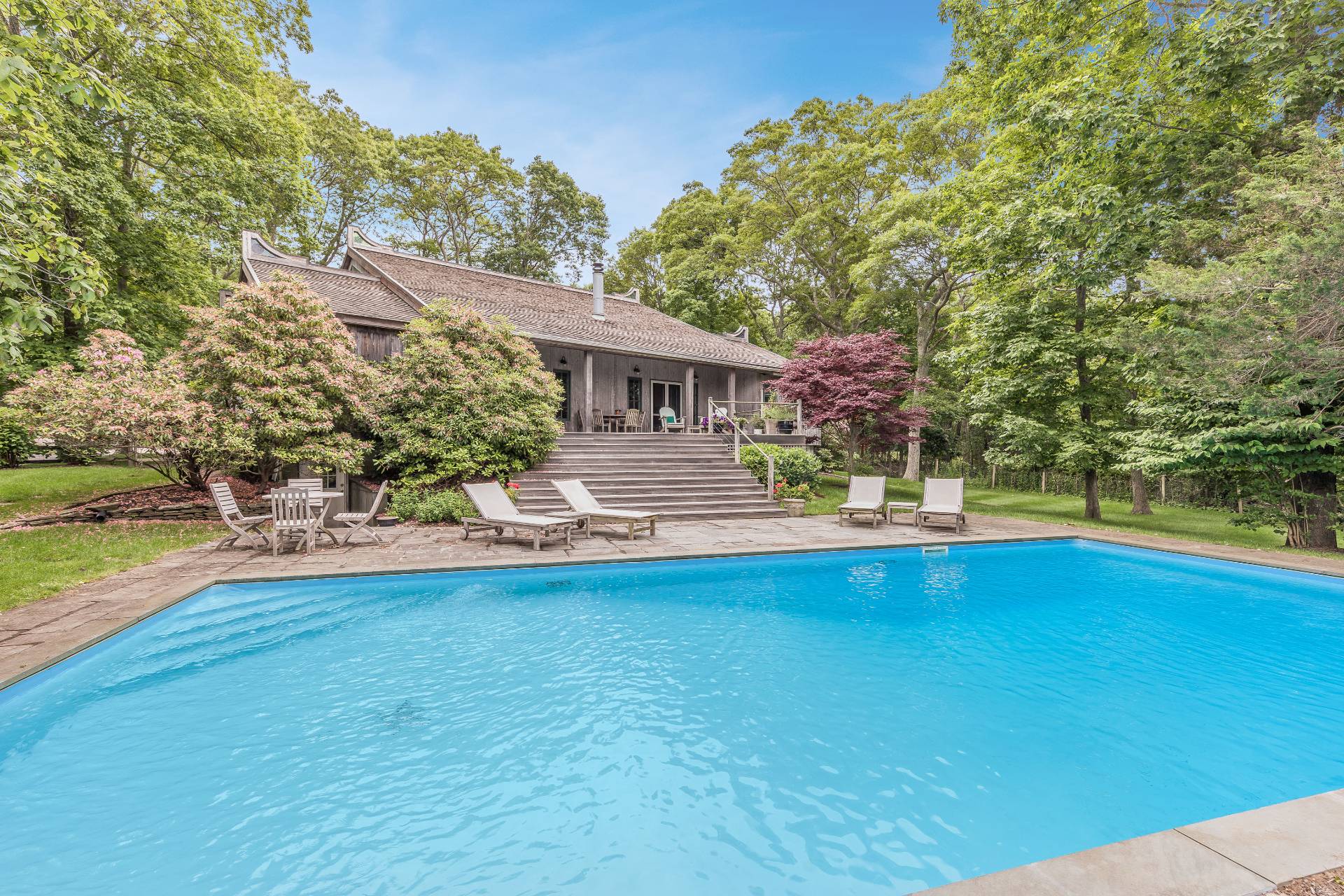 a view of a house with pool and sitting area