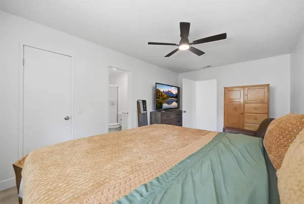 a bedroom with a large bed and a chandelier