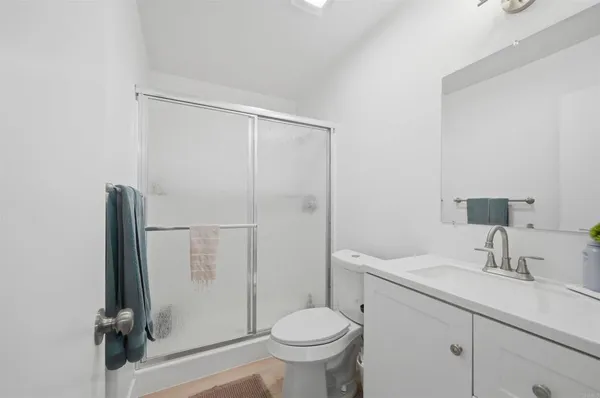 a bathroom with a granite countertop sink toilet and a mirror