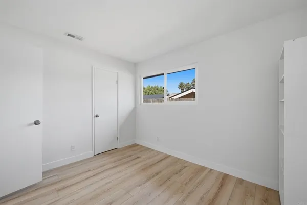 a view of a room with wooden floor and white walls