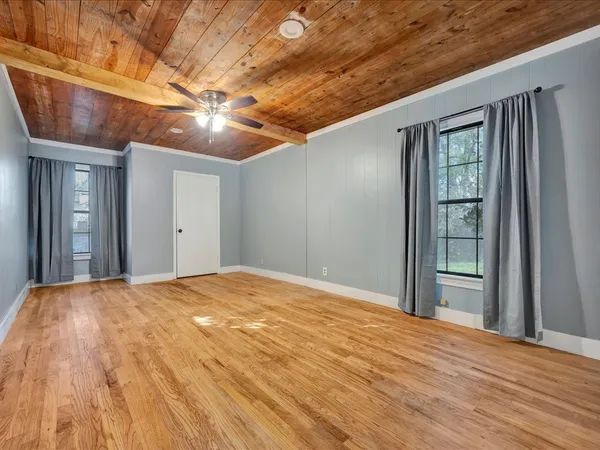 a view of an empty room with wooden floor