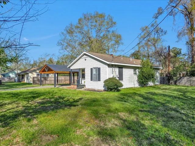 a front view of a house with yard and green space