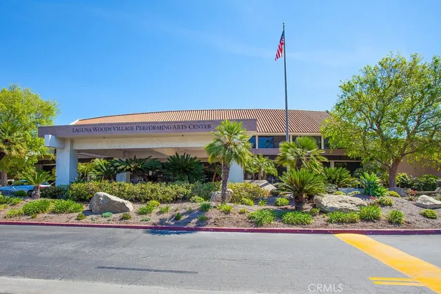 a front view of a house with a yard and potted plants