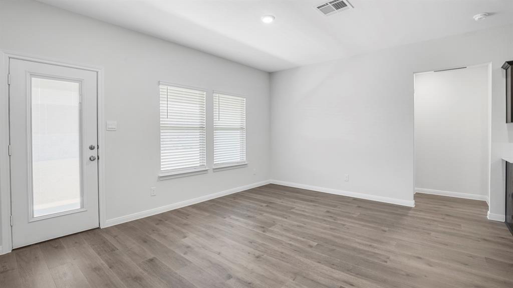 1921 Reveille Way Terrell, TX 75160 - Photo 9 of 30 an empty room with wooden floor and windows