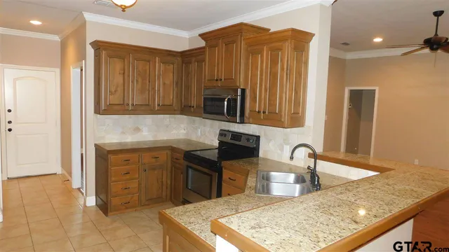 a kitchen with stainless steel appliances granite countertop a sink and a refrigerator