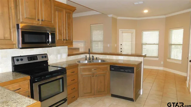 a kitchen with stainless steel appliances wooden cabinets and a stove top oven
