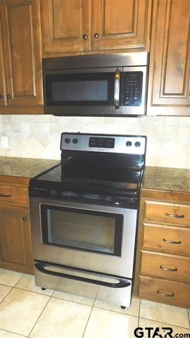 a stove top oven sitting inside of a kitchen