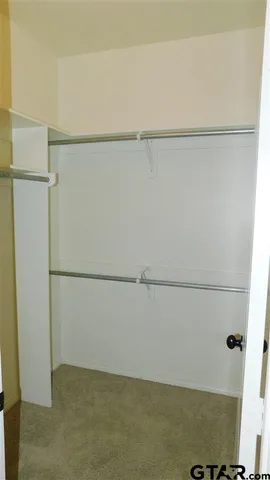 an empty room with a window and a ceiling fan