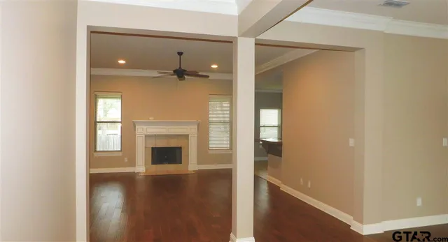 a view of a livingroom with wooden floor and a fireplace