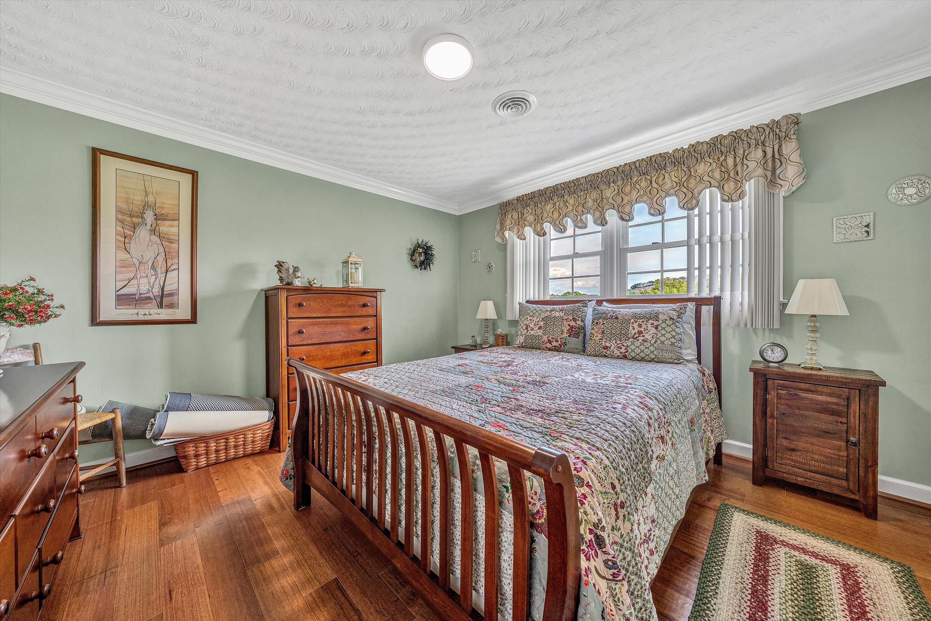 3229 Morgans Mill Road Goodview, VA 24095 - Photo 18 of 60 a bedroom with a bed and wooden floor