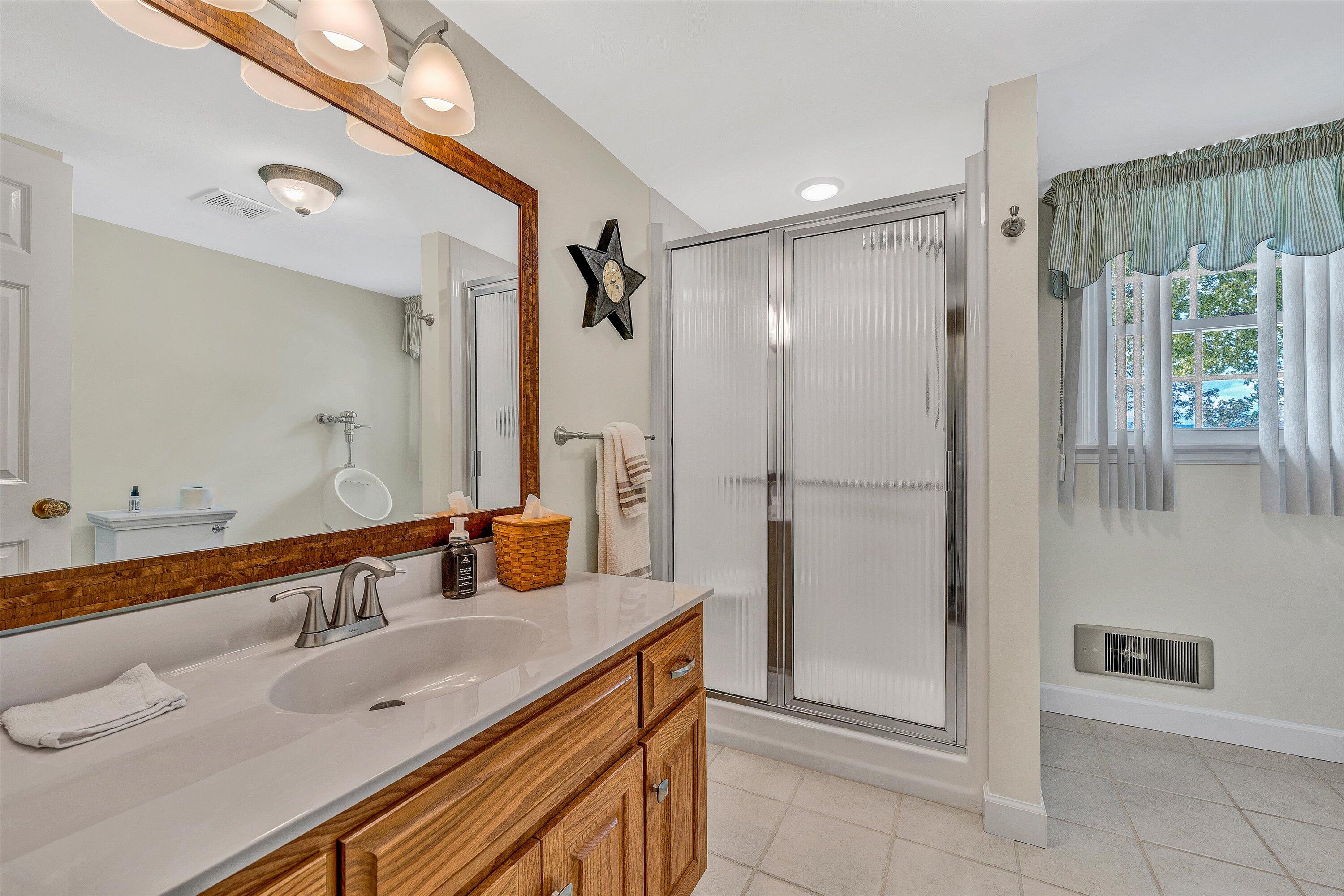 3229 Morgans Mill Road Goodview, VA 24095 - Photo 28 of 60 a bathroom with a double vanity sink mirror and shower