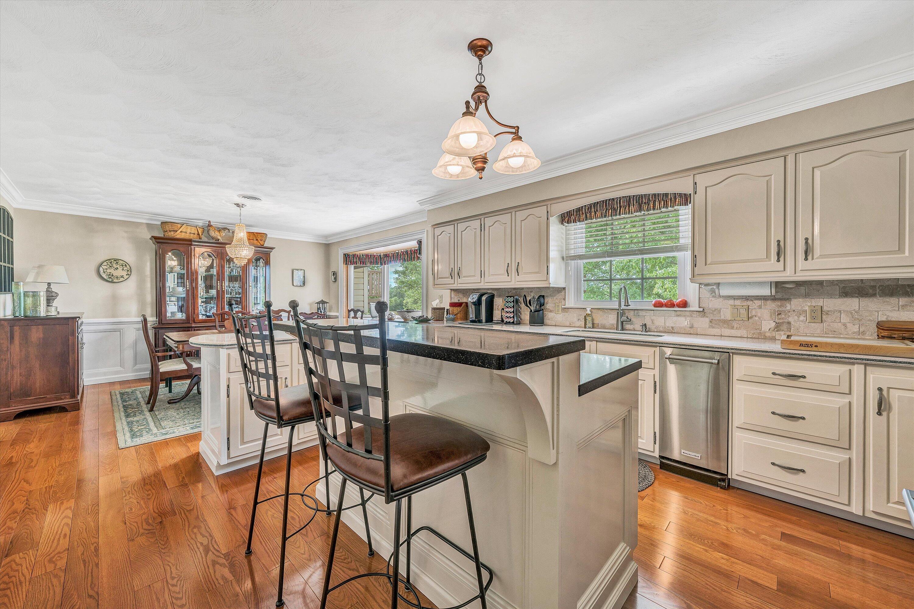 3229 Morgans Mill Road Goodview, VA 24095 - Photo 9 of 60 a kitchen with stainless steel appliances granite countertop a stove top oven a sink a dining table and chairs with wooden floor