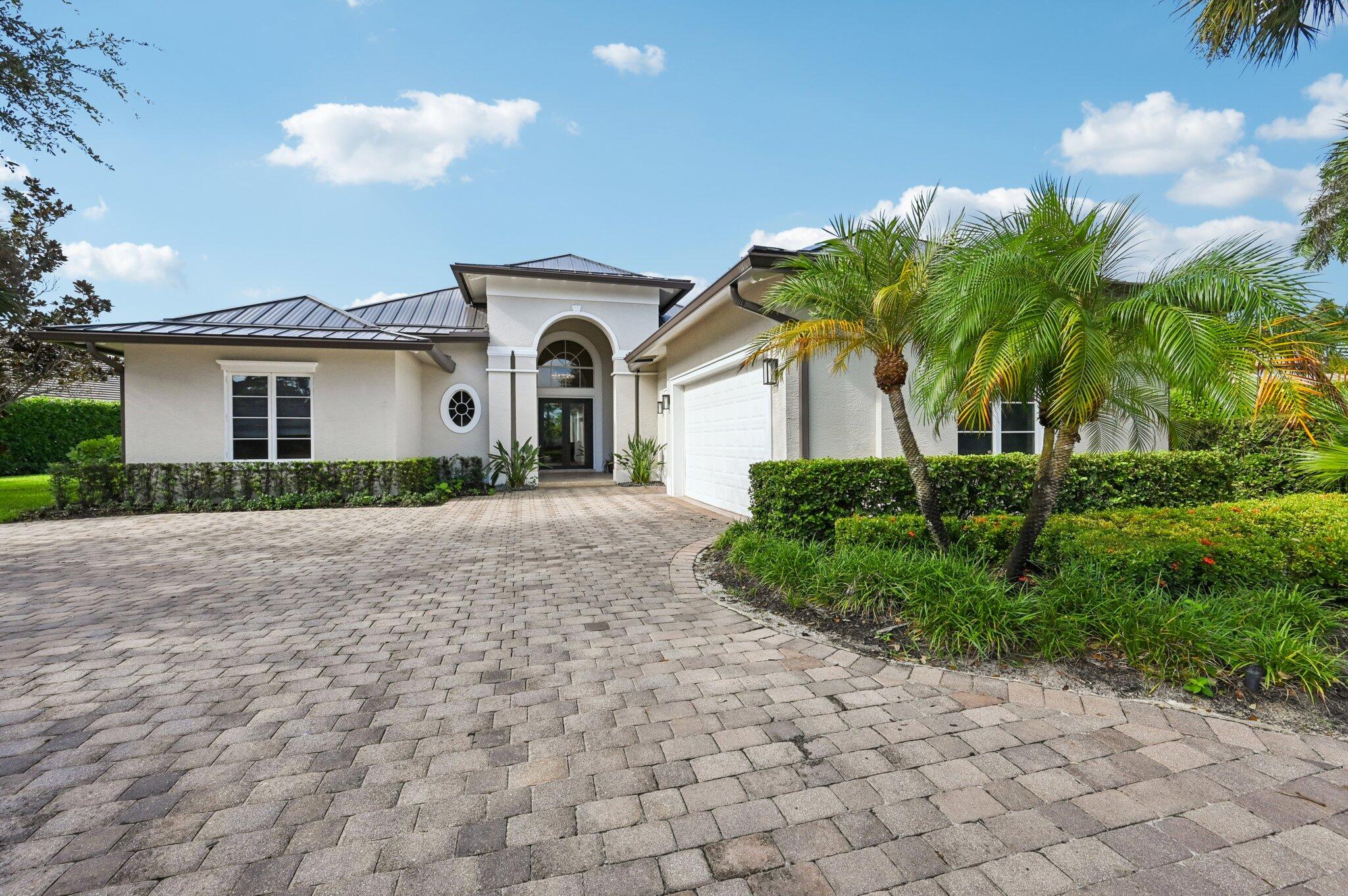 a front view of a house with a garden and trees