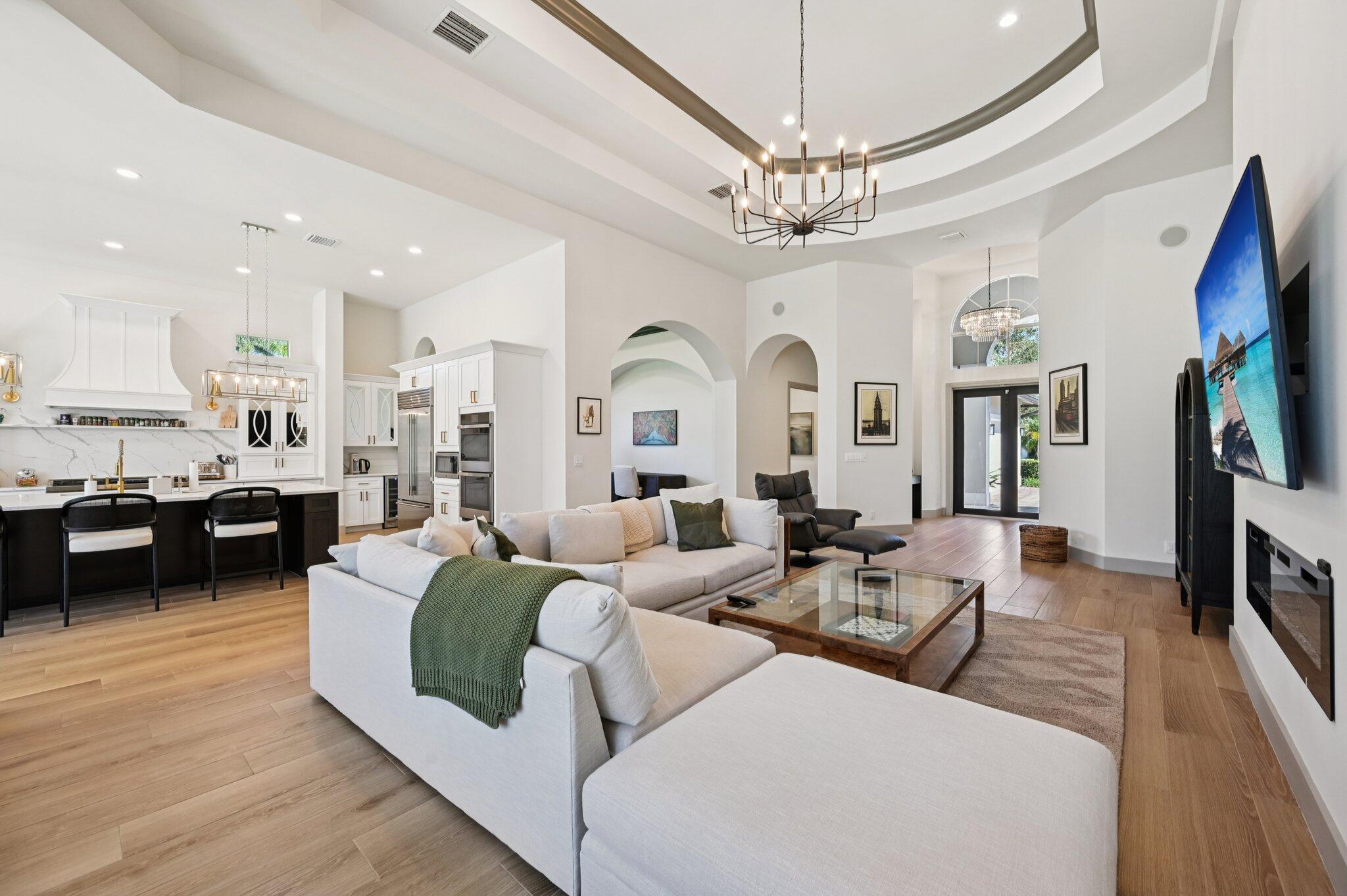 9936 Southeast Sandpine Lane Hobe Sound, FL 33455 - Photo 11 of 71 a living room with fireplace furniture and a chandelier