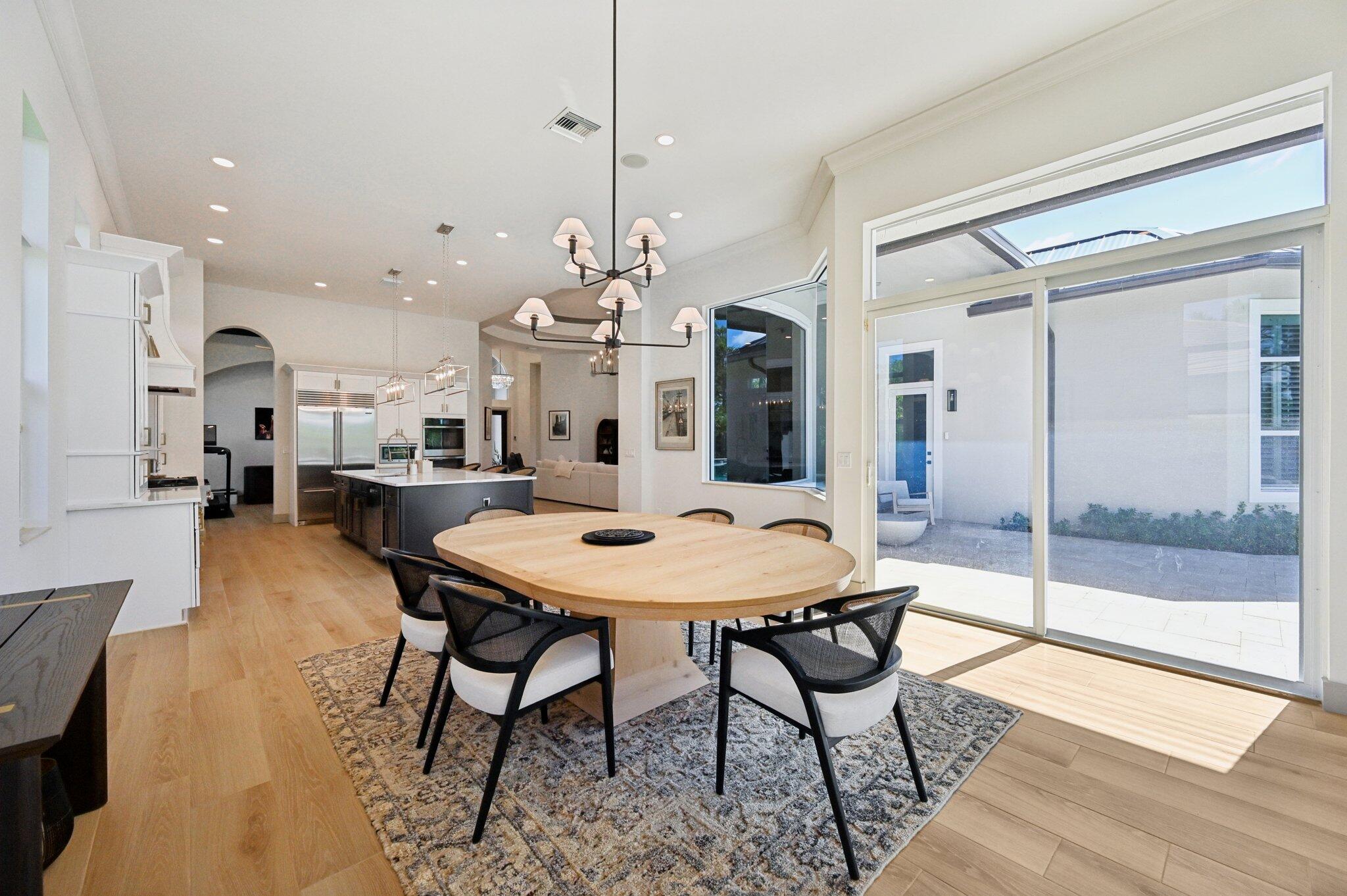 9936 Southeast Sandpine Lane Hobe Sound, FL 33455 - Photo 13 of 71 a view of a dining room and livingroom with furniture wooden floor a chandelier