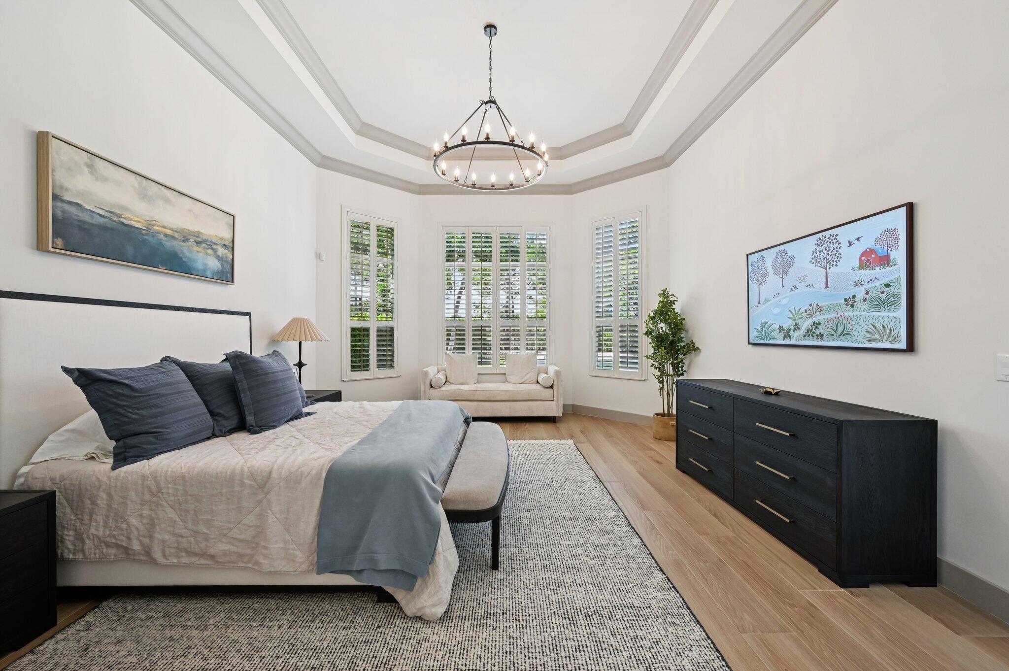 9936 Southeast Sandpine Lane Hobe Sound, FL 33455 - Photo 19 of 71 a spacious bedroom with a bed and a chandelier