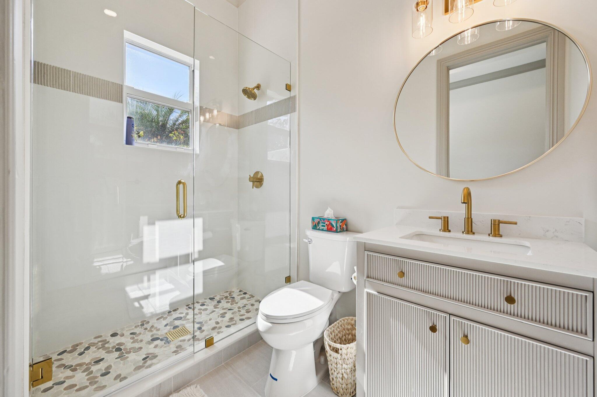 9936 Southeast Sandpine Lane Hobe Sound, FL 33455 - Photo 30 of 71 a bathroom with a sink a toilet and a mirror