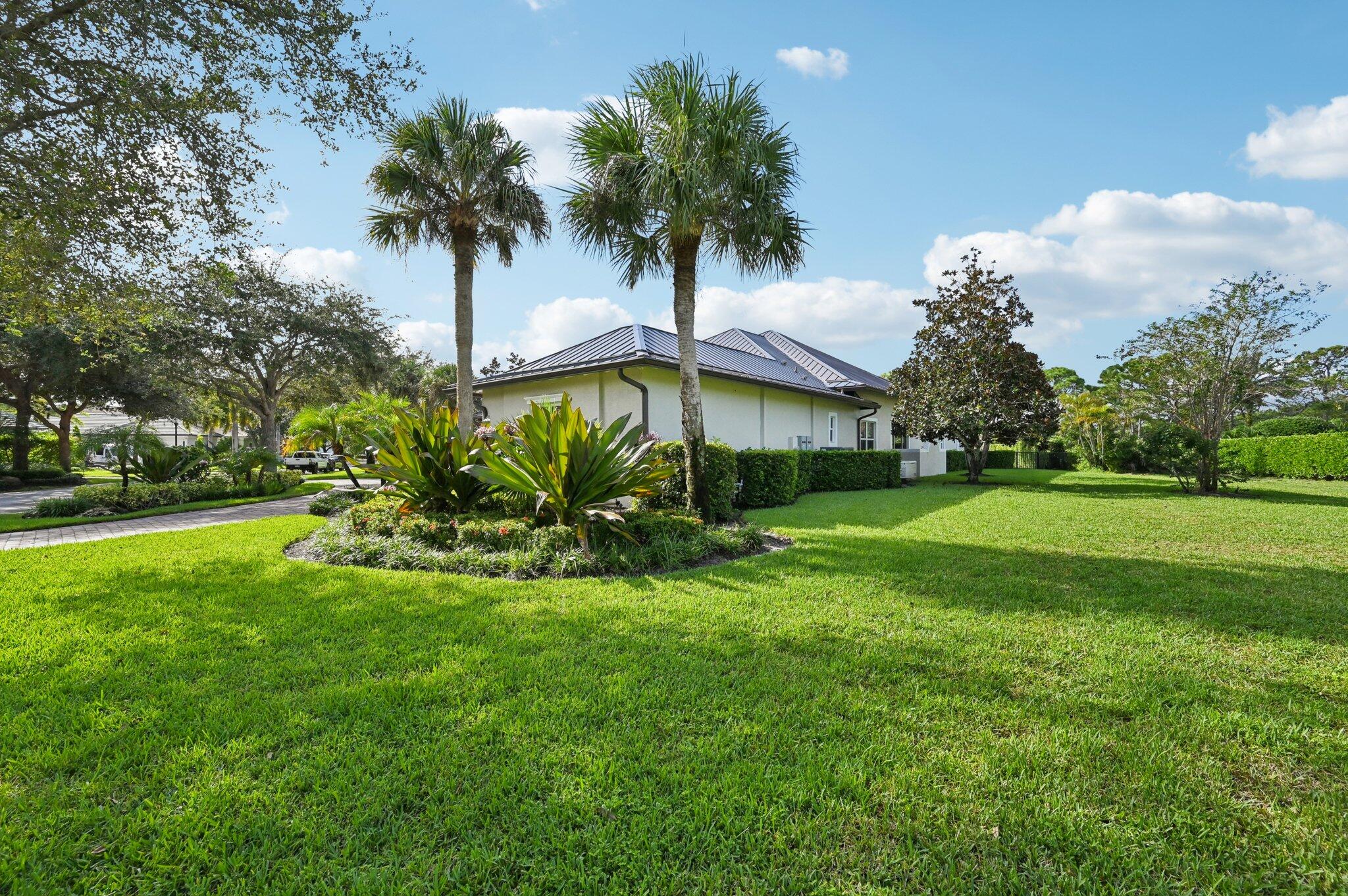 9936 Southeast Sandpine Lane Hobe Sound, FL 33455 - Photo 48 of 71 a palm tree sitting in front of a house with a big yard