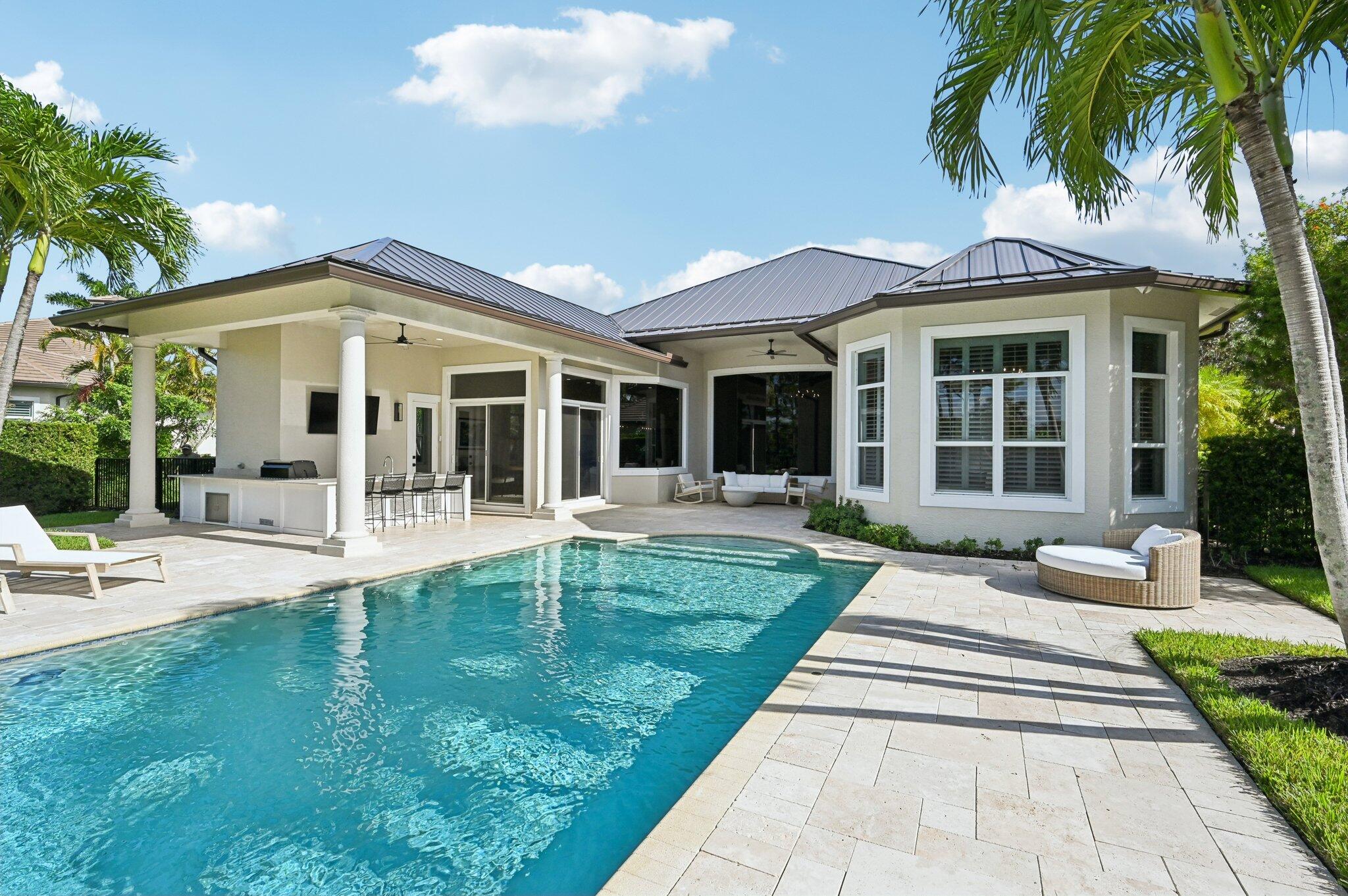 9936 Southeast Sandpine Lane Hobe Sound, FL 33455 - Photo 5 of 71 a view of a patio with table and chairs potted plants and palm tree