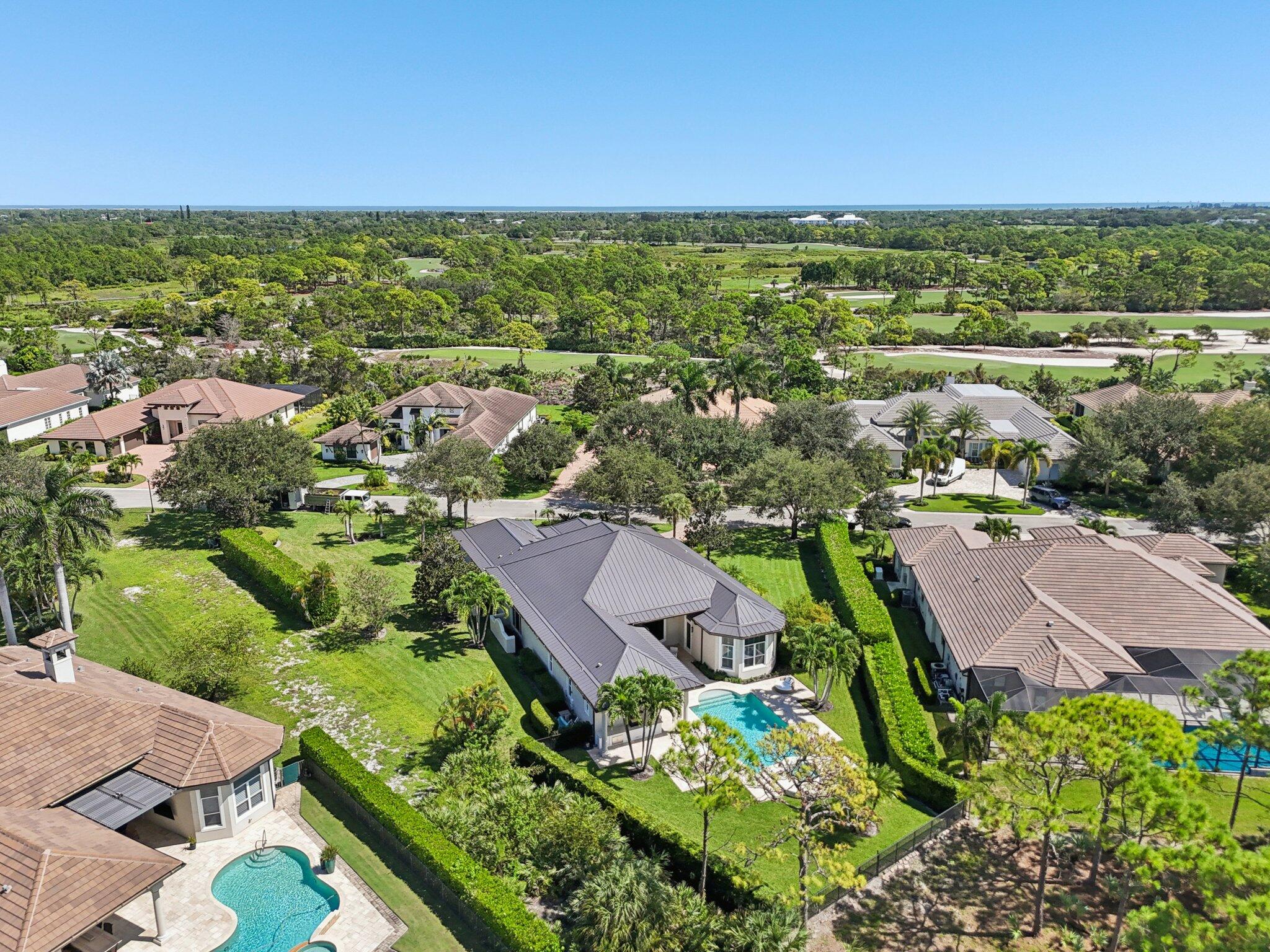 9936 Southeast Sandpine Lane Hobe Sound, FL 33455 - Photo 58 of 71 an aerial view of residential houses with outdoor space and trees