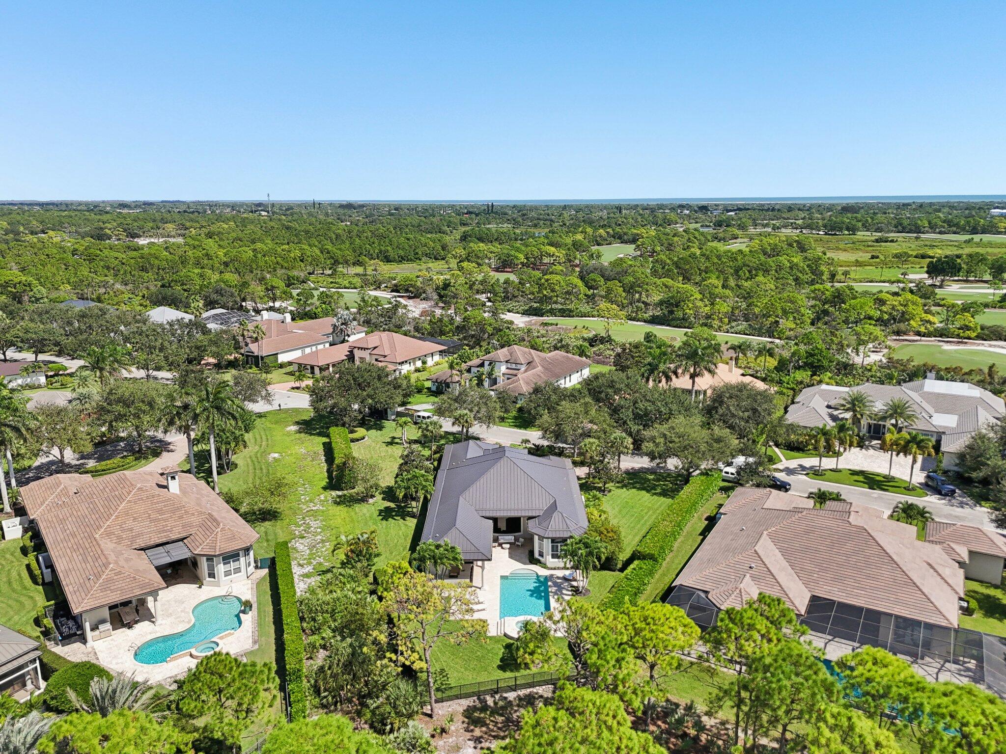 9936 Southeast Sandpine Lane Hobe Sound, FL 33455 - Photo 60 of 71 an aerial view of residential houses with outdoor space and trees