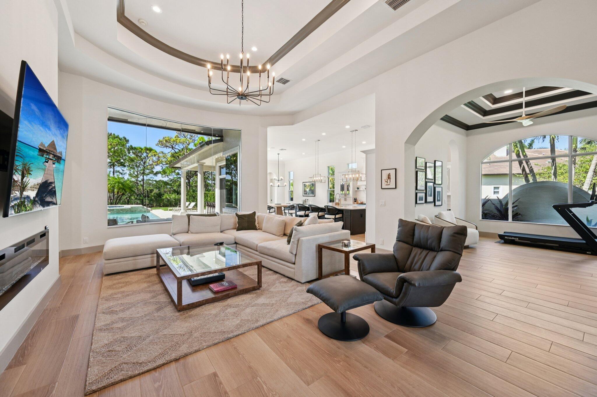9936 Southeast Sandpine Lane Hobe Sound, FL 33455 - Photo 9 of 71 a living room with furniture a flat screen tv and a large window