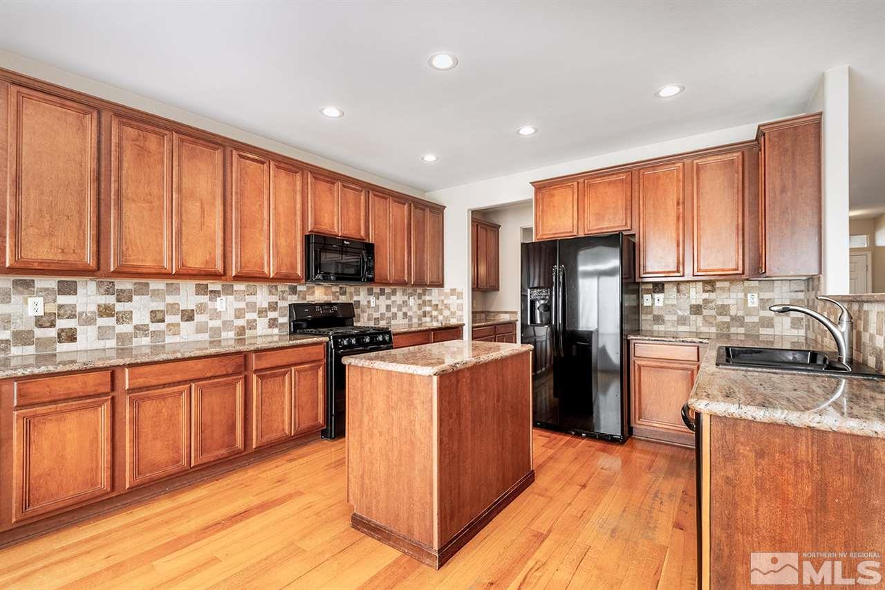 10840 Dancing Aspen Drive Reno, NV 89521 - Photo 8 of 24 a kitchen with stainless steel appliances granite countertop a refrigerator stove microwave and sink