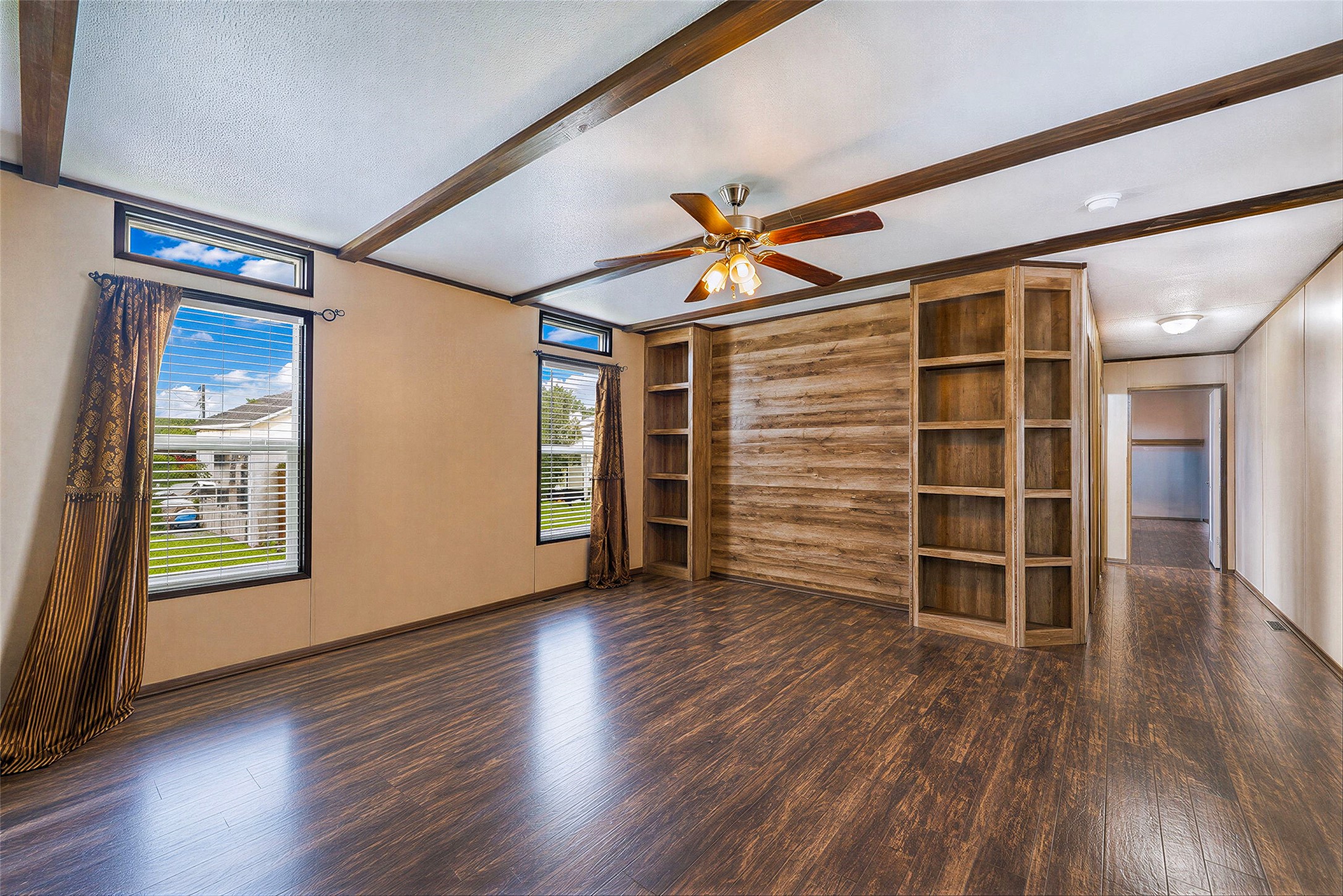 935 Lower Red Rock Road Bastrop, TX 78602 - Photo 5 of 25 Living area featuring laminate flooring, a ceiling fan and exposed ceiling beams, ideal for entertaining.