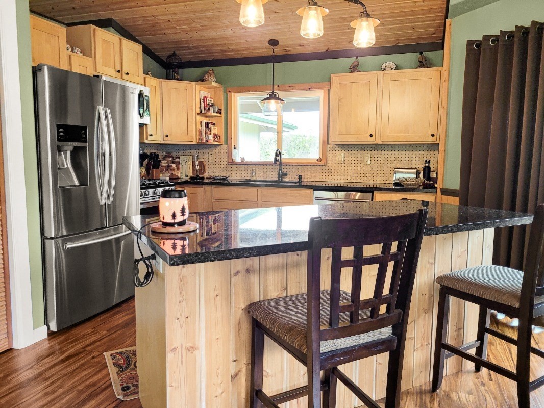 18-8079 North Kulani Road Mountain View, HI 96771 - Photo 8 of 27 a kitchen with stainless steel appliances granite countertop a stove refrigerator and a chair