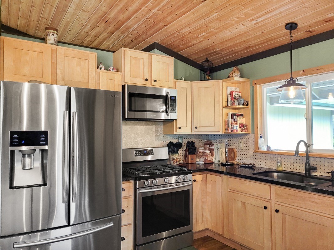 18-8079 North Kulani Road Mountain View, HI 96771 - Photo 9 of 27 a kitchen with stainless steel appliances a refrigerator sink and microwave