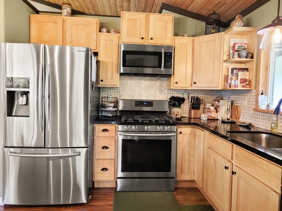 18-8079 North Kulani Road Mountain View, HI 96771 - Photo 10 of 27 a kitchen with stainless steel appliances a refrigerator sink and microwave