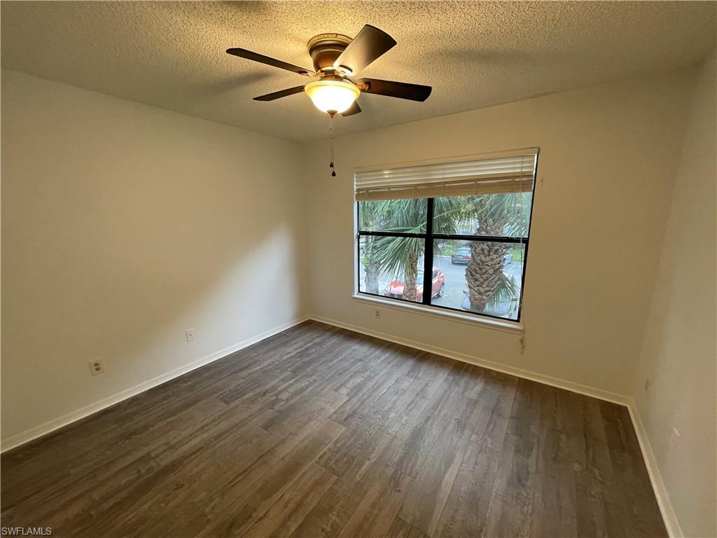2142 Arbour Walk Circle, Unit 2624 Naples, FL 34109 - Photo 7 of 13 an empty room with wooden floor fan and windows
