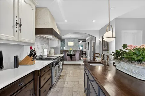 a kitchen with stainless steel appliances a stove a sink a oven a dining table and chairs