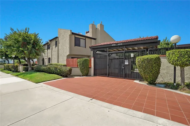 a view of a house with a small yard and a large tree