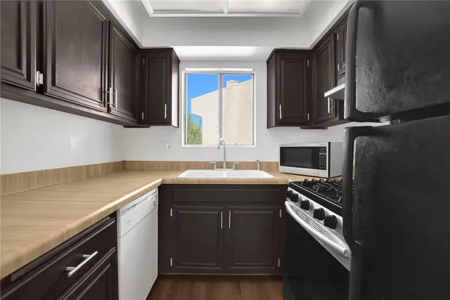 a kitchen with stainless steel appliances a sink stove and cabinets