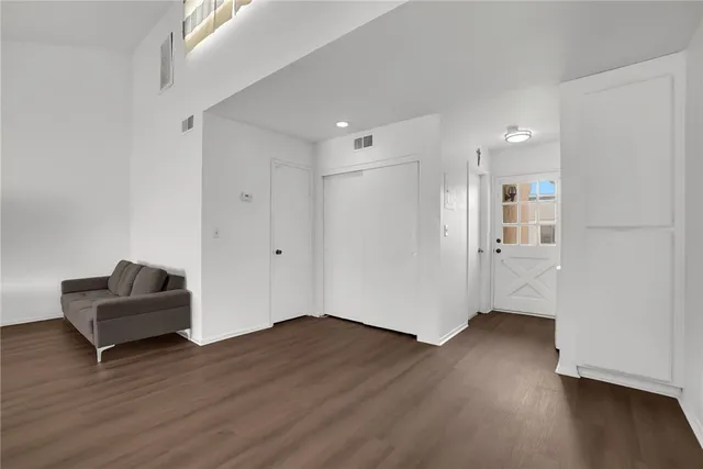 a view of a big room with wooden floor and windows