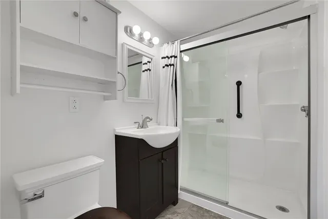 a bathroom with a sink a toilet and shower