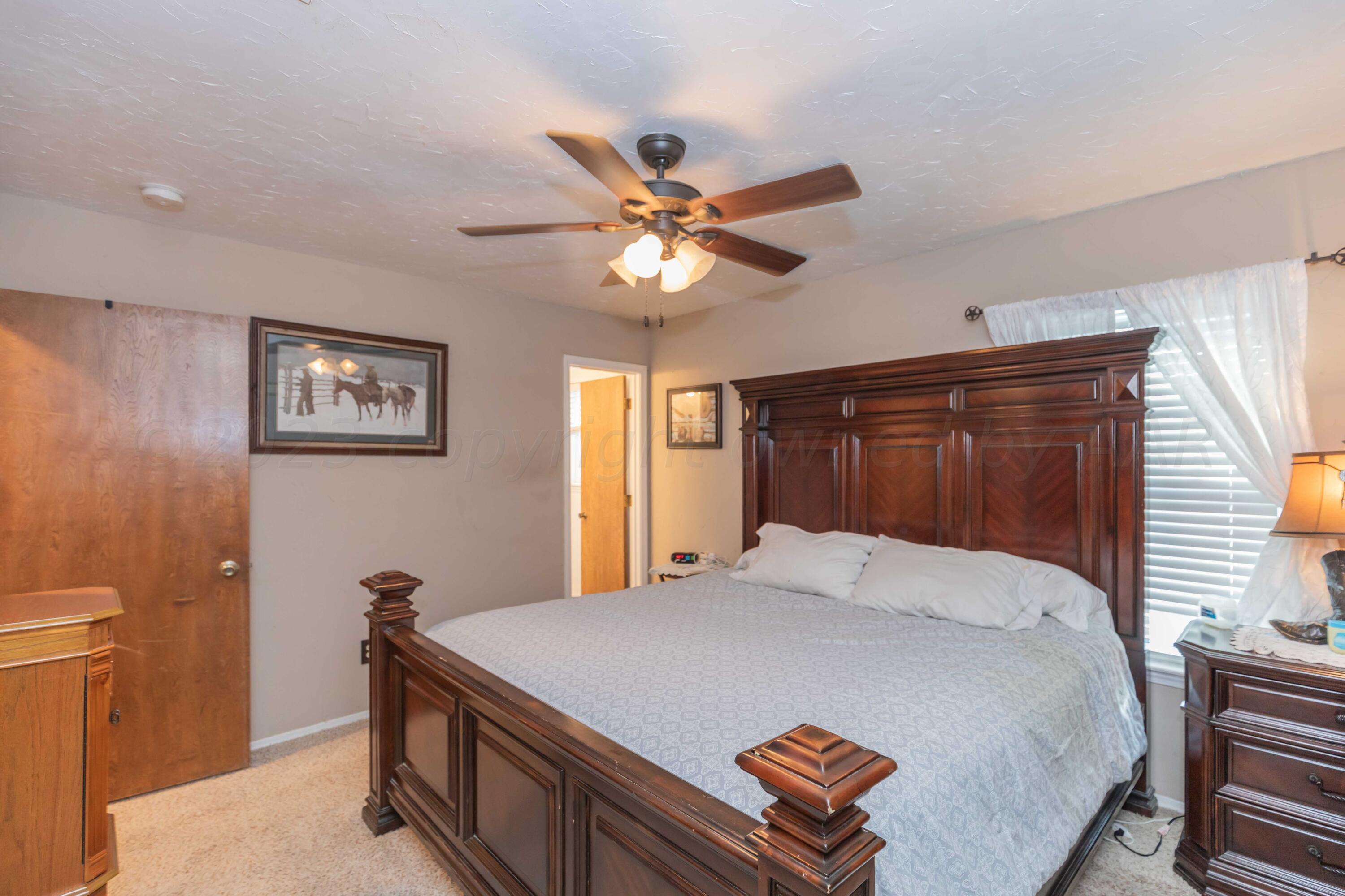 2805 Shield Court Amarillo, TX 79110 - Photo 15 of 36 a bedroom with a bed and a chandelier