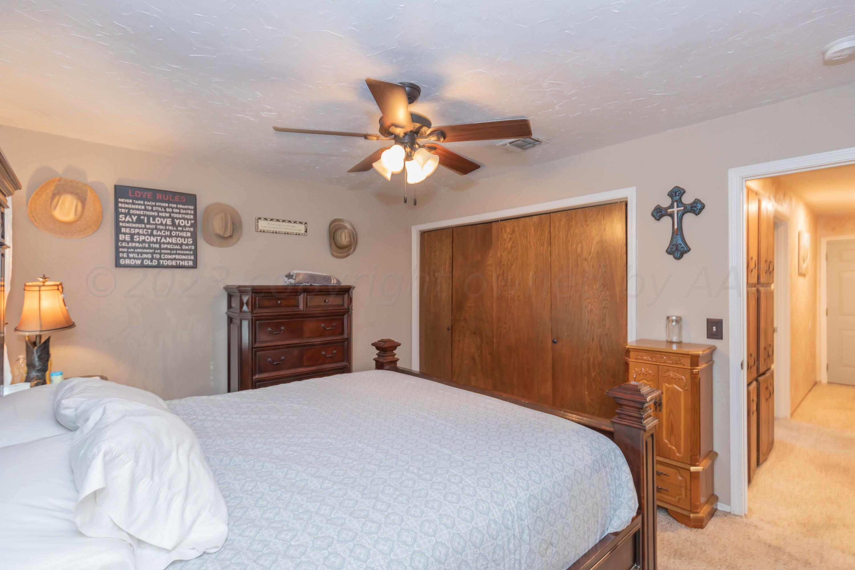 2805 Shield Court Amarillo, TX 79110 - Photo 16 of 36 a bedroom with a bed and a chandelier