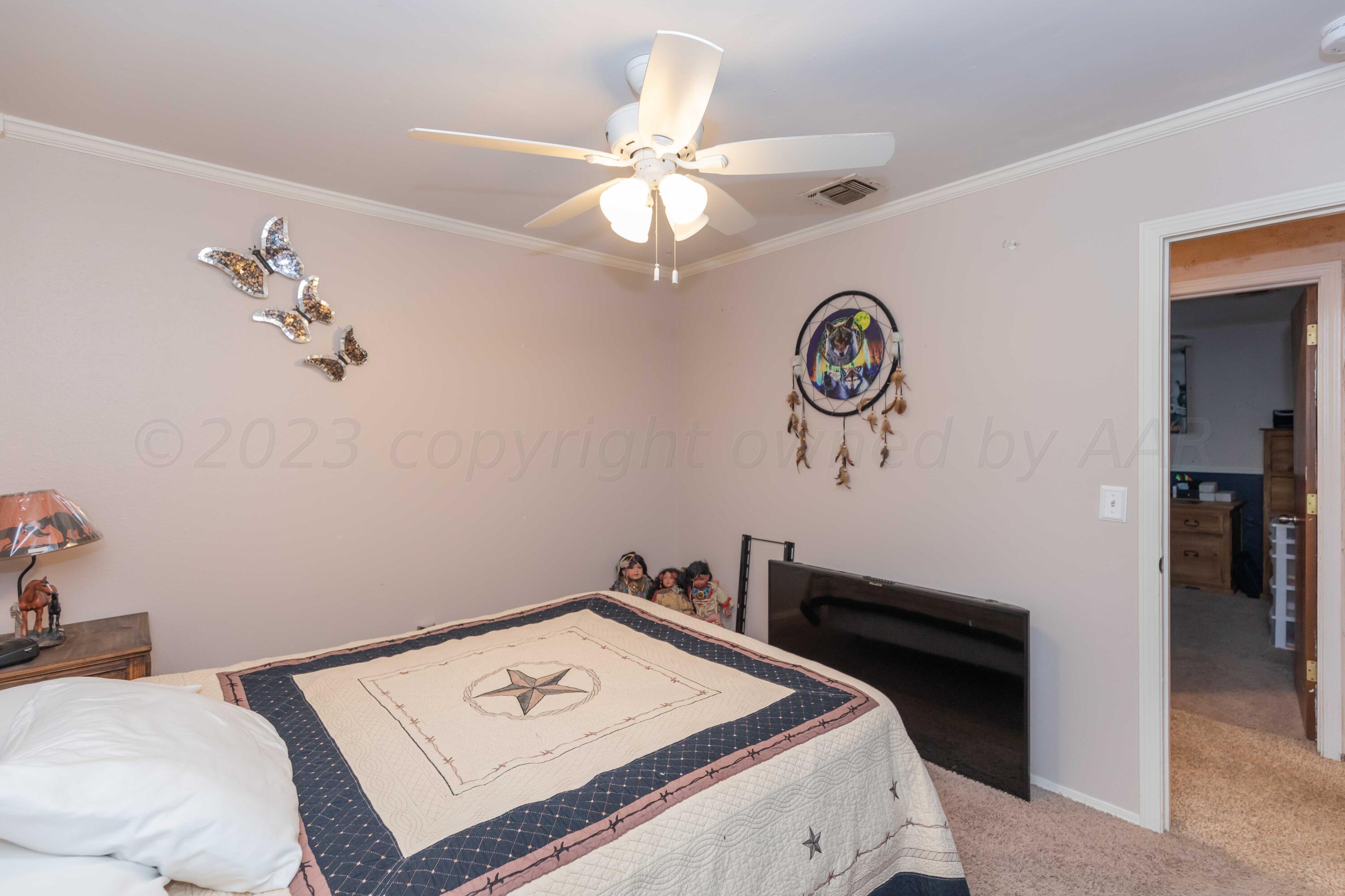 2805 Shield Court Amarillo, TX 79110 - Photo 21 of 36 a bedroom with a bed and a chandelier