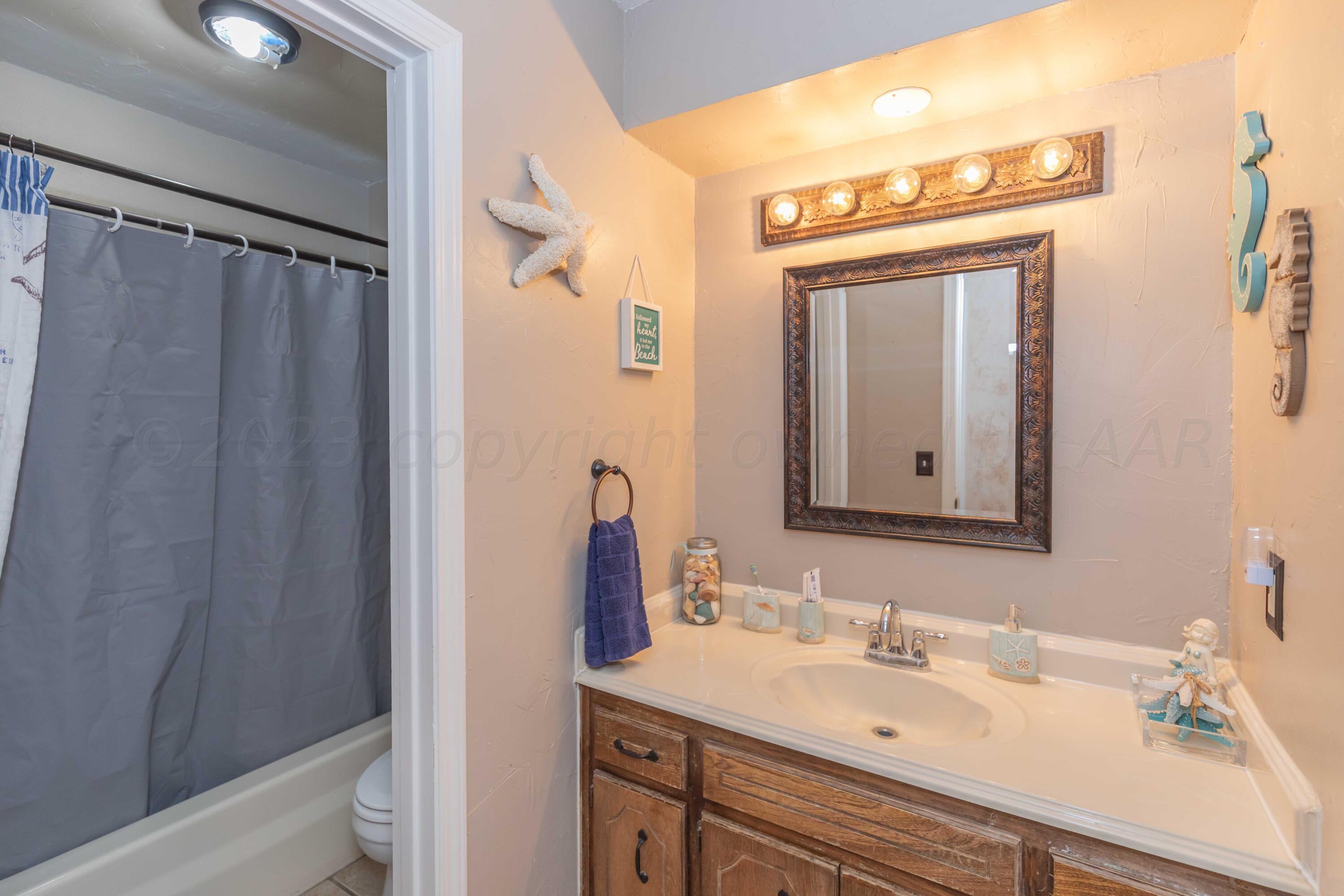 2805 Shield Court Amarillo, TX 79110 - Photo 24 of 36 a bathroom with a sink a mirror and a shower